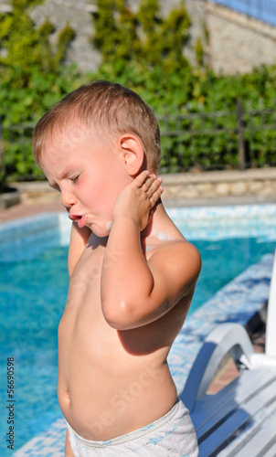 Fotografi Young boy applying suntan lotion