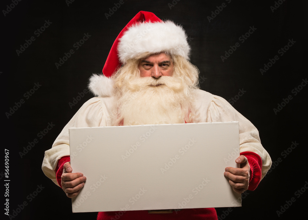 Naklejka premium Santa Claus holding white blank sign