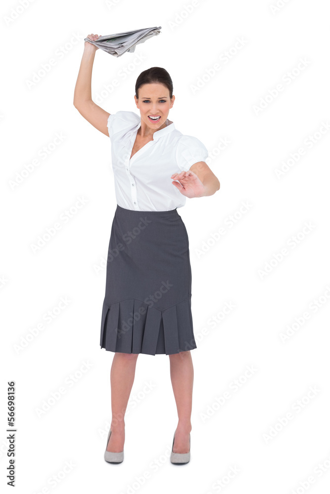 Angry stylish businesswoman throwing newspaper away Angry stylish businesswoman throwing newspaper away