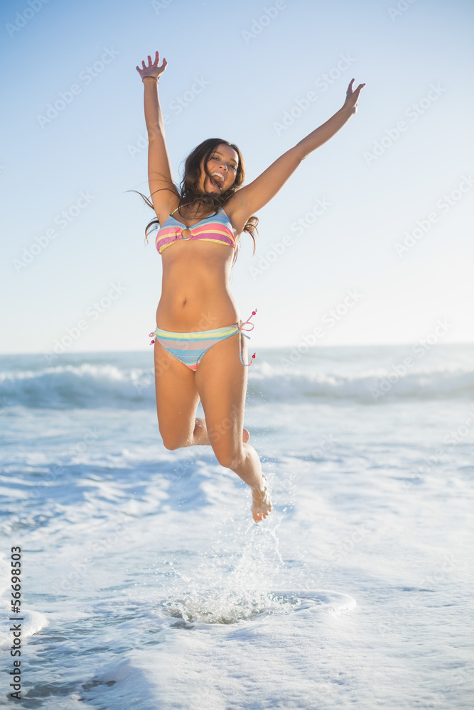 Laughing woman in bikini jumping in the sea Laughing woman in bikini jumping in the sea