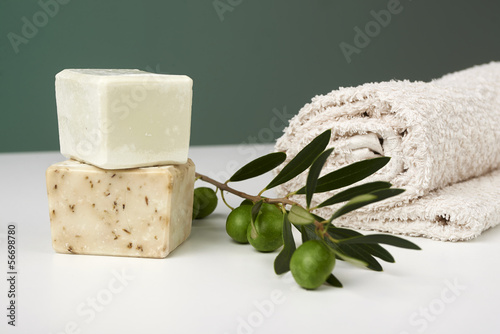 Handmade olive soap with olive branch and a towel. photo