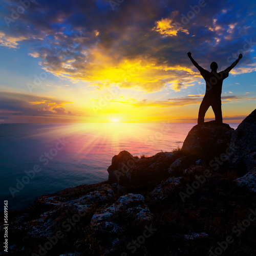 happy man stay on a sea coast at the sunset