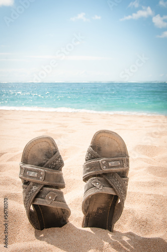 Sandals in the sand of a tropical beach