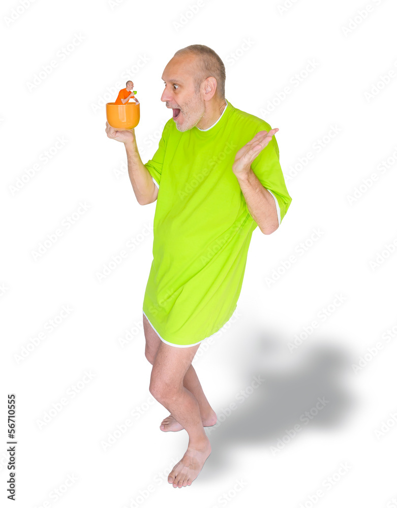 A man in green nightdress surprised to see himself in his coffee cup A man in green nightdress surprised to see himself in his coffee cup