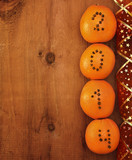 oranges with clove numbers on wooden background