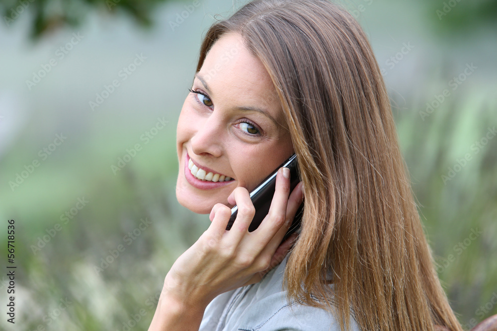 Woman in park talking on mobile phone Woman in park talking on mobile phone