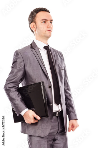 Portrait of a young businessman holding a laptop under his arm