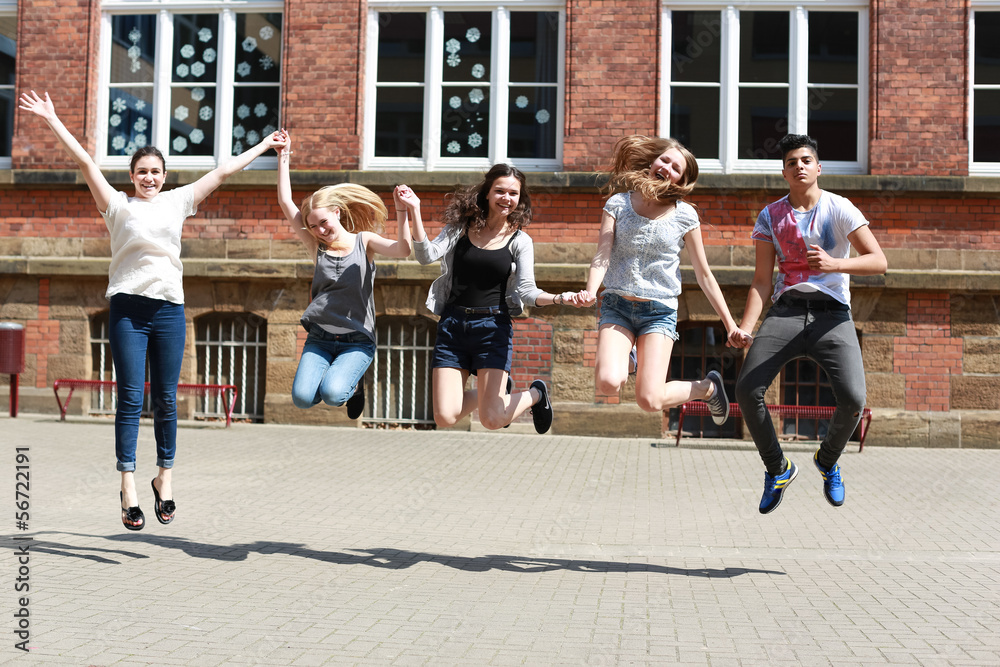 fröhliche Schüler springen draußen