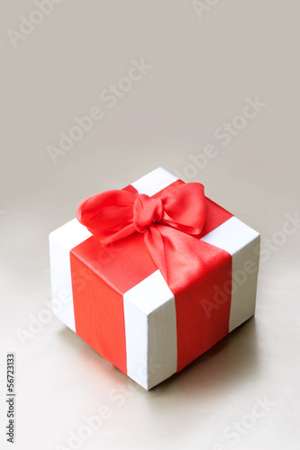 Holiday background with gift box and red ribbon. Still life.