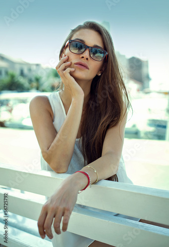 Yound woman on bench wearing sunglasses