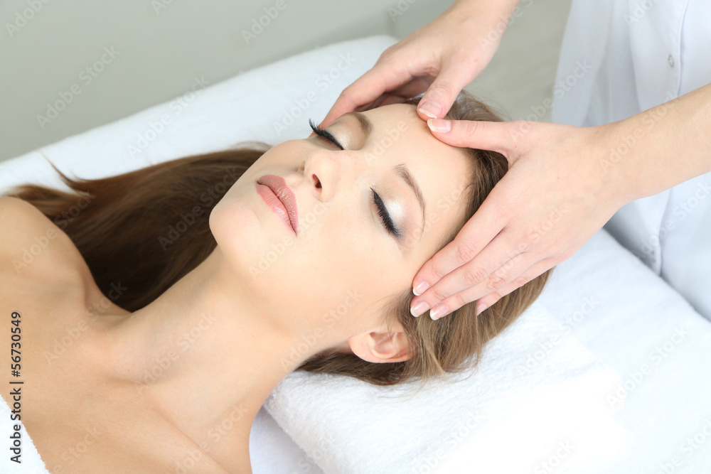 Beautiful young woman during facial massage in cosmetic salon Beautiful young woman during facial massage in cosmetic salon