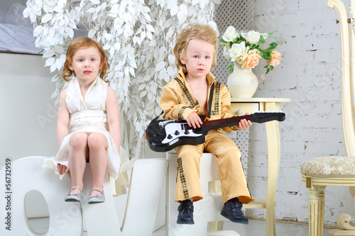 A little girl and pop musician with guitar sit on letters love