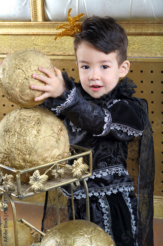 boy in suit of black prince raises the golden ball photo