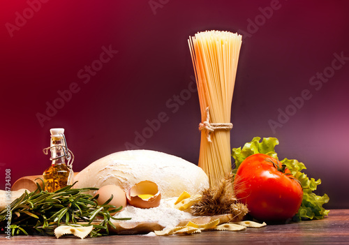 ingredients for homemade pasta on wooden table on brown backgrou