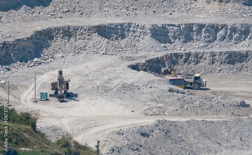 Extracting stone from rock and transporting by truck photo