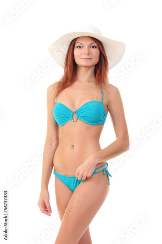 Red-haired beauty in a bikini and beach hat