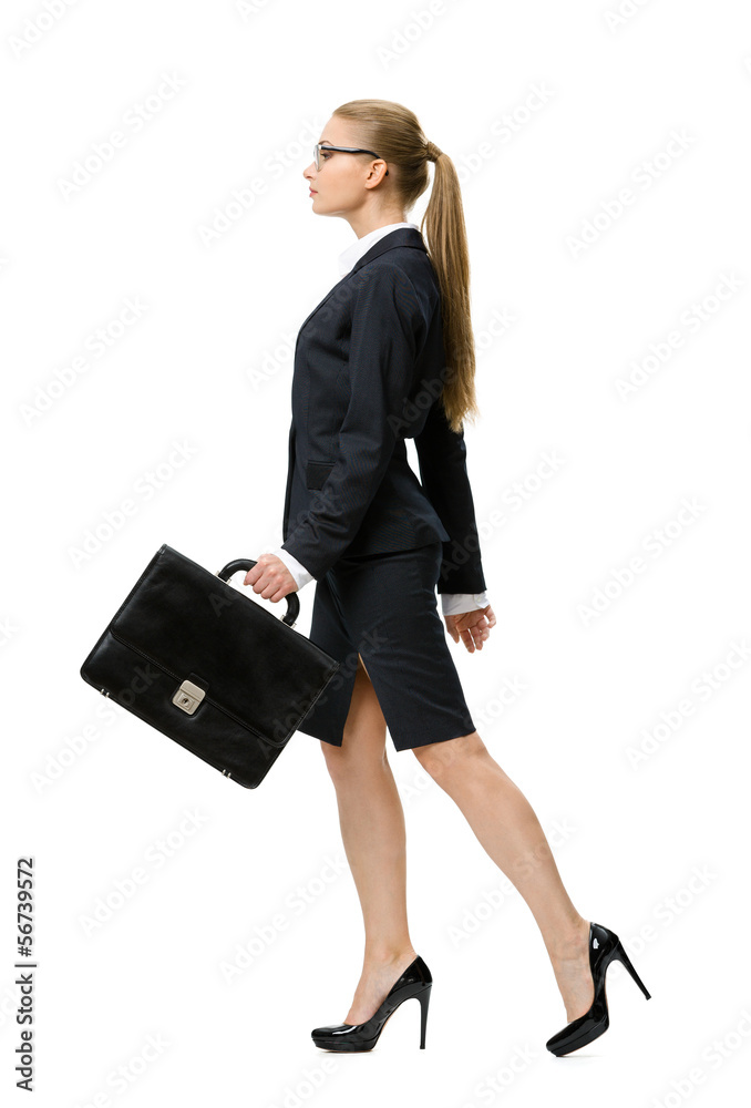 Profile of walking businesswoman handing suitcase Profile of walking businesswoman handing suitcase