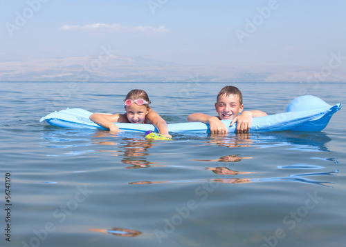 girl with a boy on a mattress swim © Olexandr