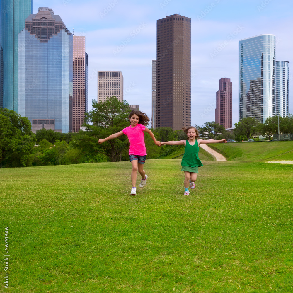 Two sister girls friends running holding hand in urban skyline