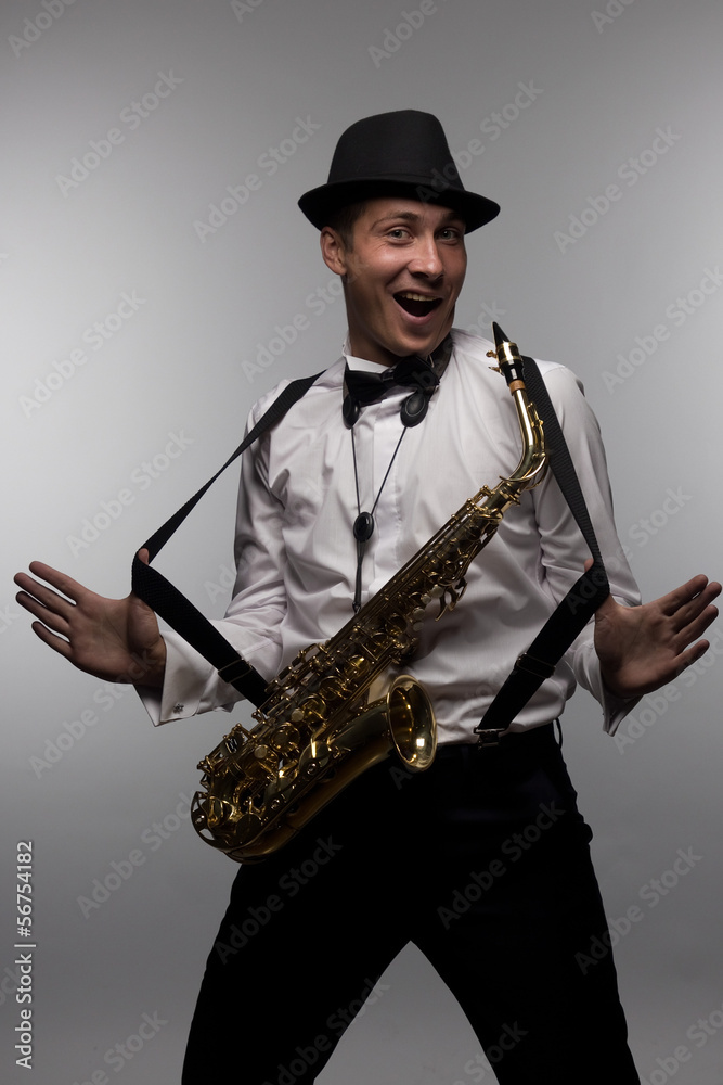 Naklejka premium Portrait of happy and smiling saxophone player with hat. 