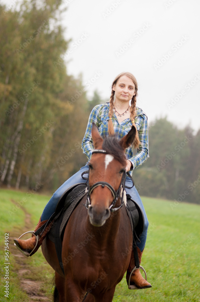 Obraz premium A girl rides a horse on the field