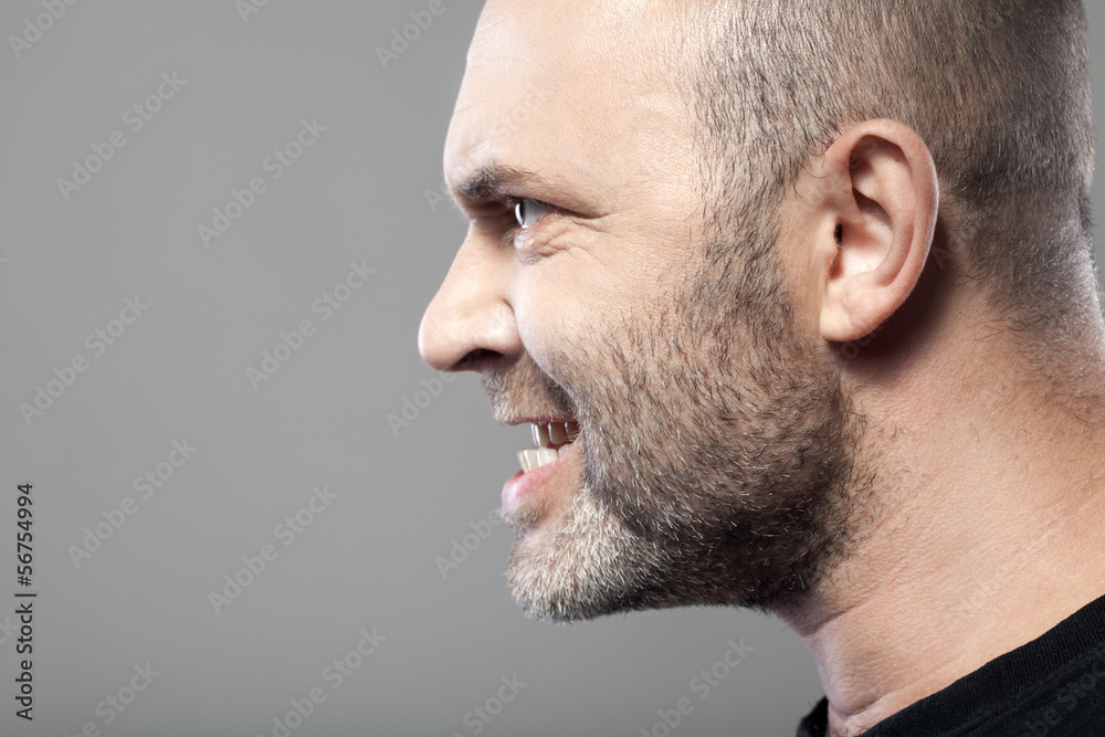 portrait of angry man isolated on gray background with copyspace portrait of angry man isolated on gray background with copyspace