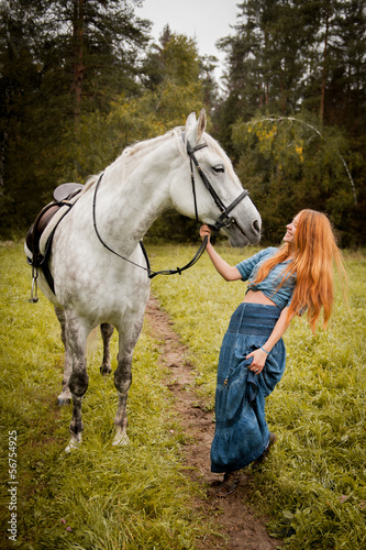 The girl with red hair and a white horse