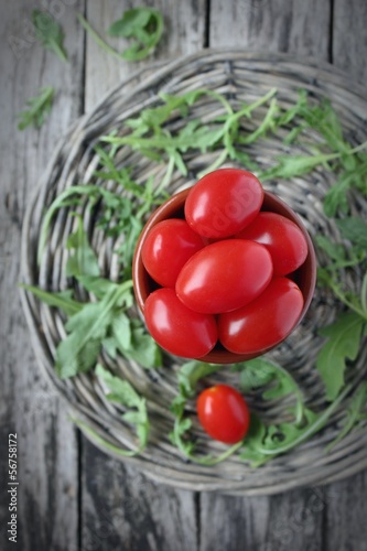 Cherry tomatos on wooden background (vignette) photo