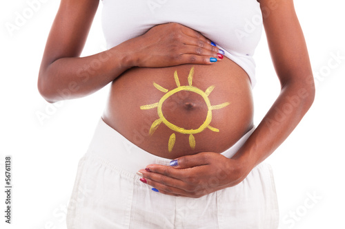 Young pregnant black woman touching her painted belly - African