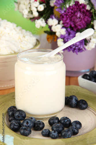Fresh dairy products with blueberry on wooden table close-up