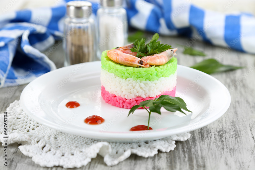 Colored rice on plate near napkin on wooden table Colored rice on plate near napkin on wooden table