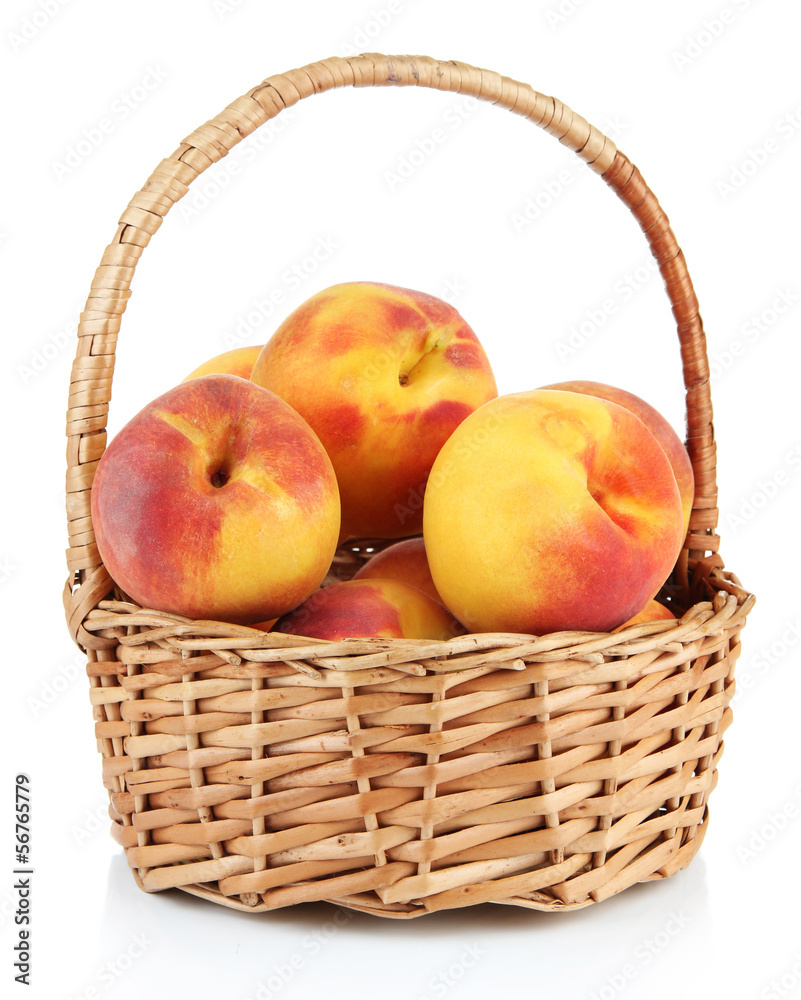 Ripe sweet peaches in wicker basket, isolated on white
