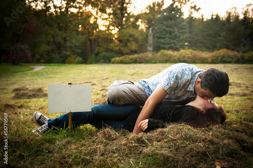 Loving couple lying on the grass and kissing