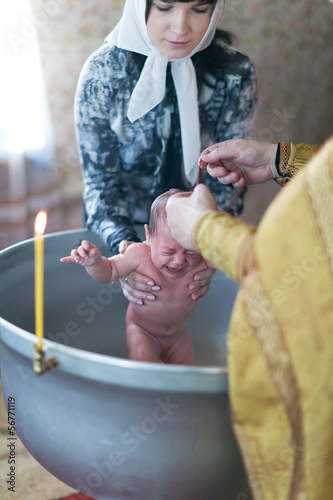 Priest at Sretenskaya church performing christening ceremony photo