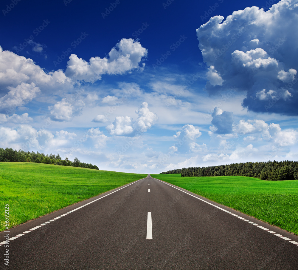 Asphalt road in green fields under beautiful sky Asphalt road in green fields under beautiful sky