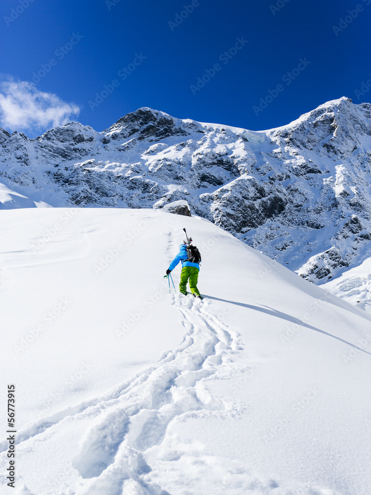 Freeride - Man with skis climbs to the top