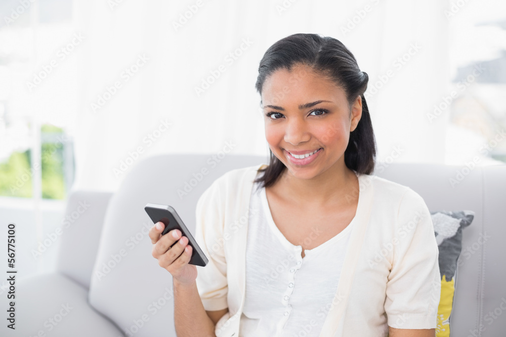 Pretty young dark haired woman in white clothes holding a mobile Pretty young dark haired woman in white clothes holding a mobile