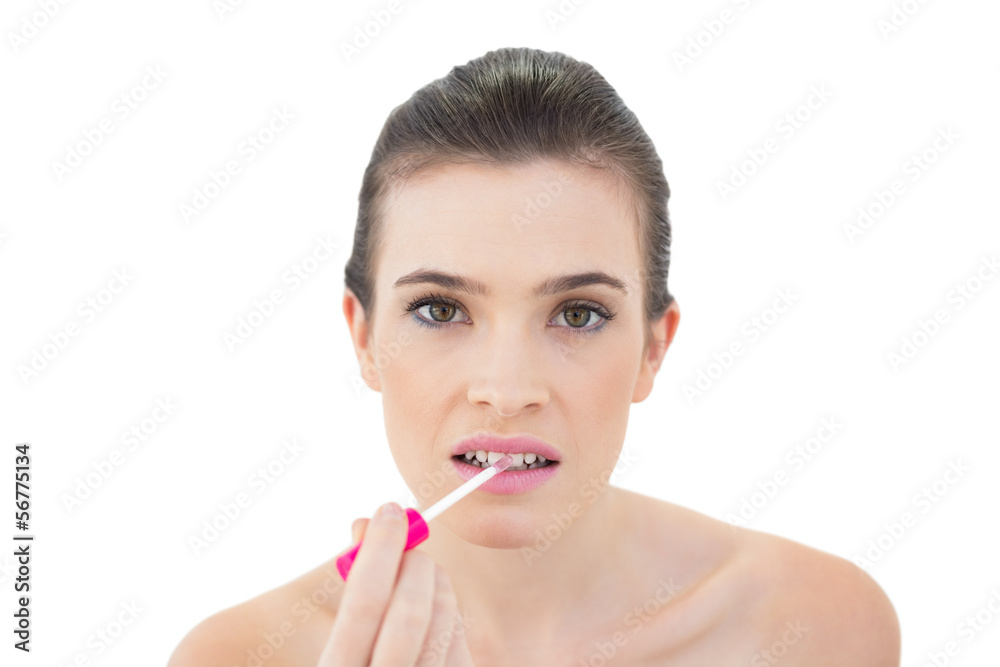 Attractive natural brown haired model applying gloss Attractive natural brown haired model applying gloss