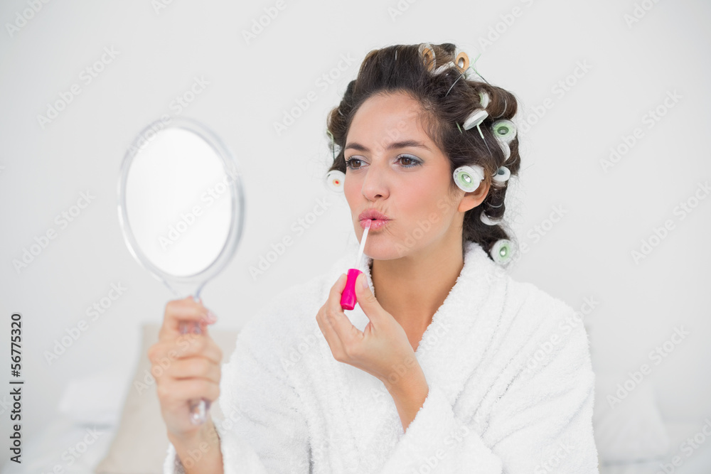 Calm natural brunette applying lip gloss Calm natural brunette applying lip gloss