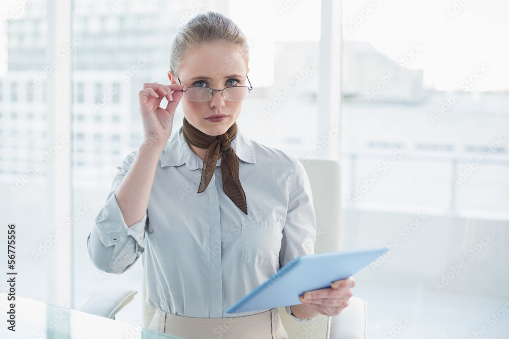 Blonde frowning businesswoman holding tablet Blonde frowning businesswoman holding tablet