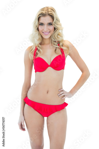 Attractive smiling blonde model posing with hand on hips wearing