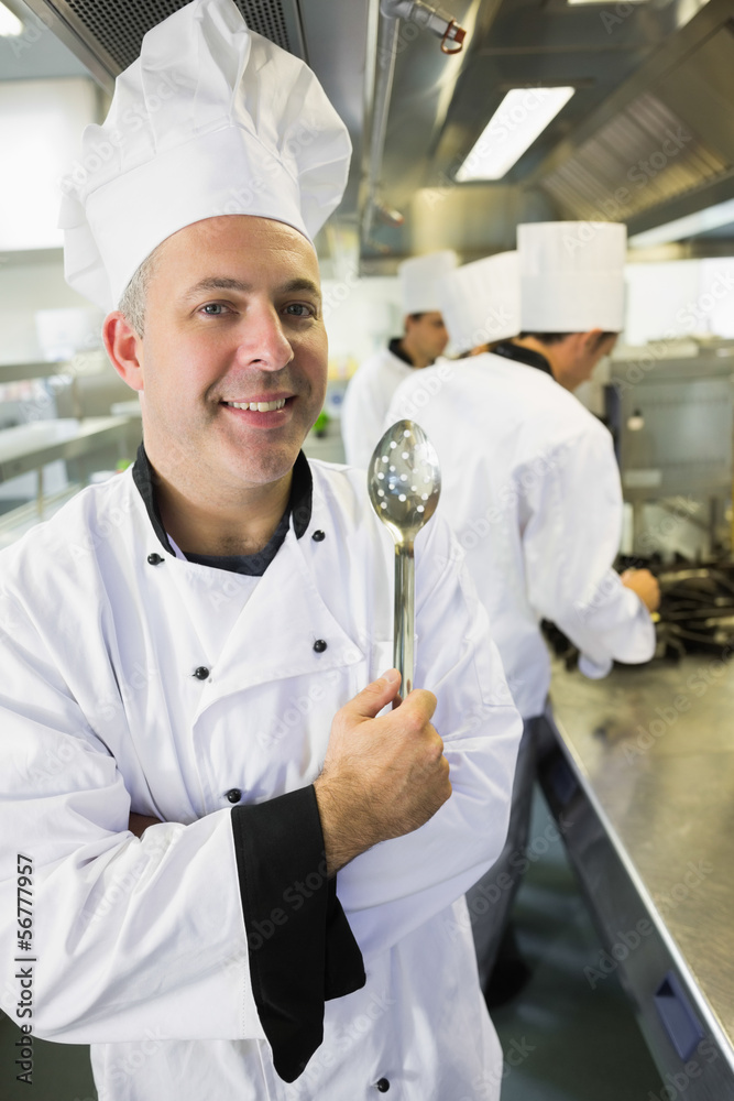 Senior chef posing proudly in a kitchen