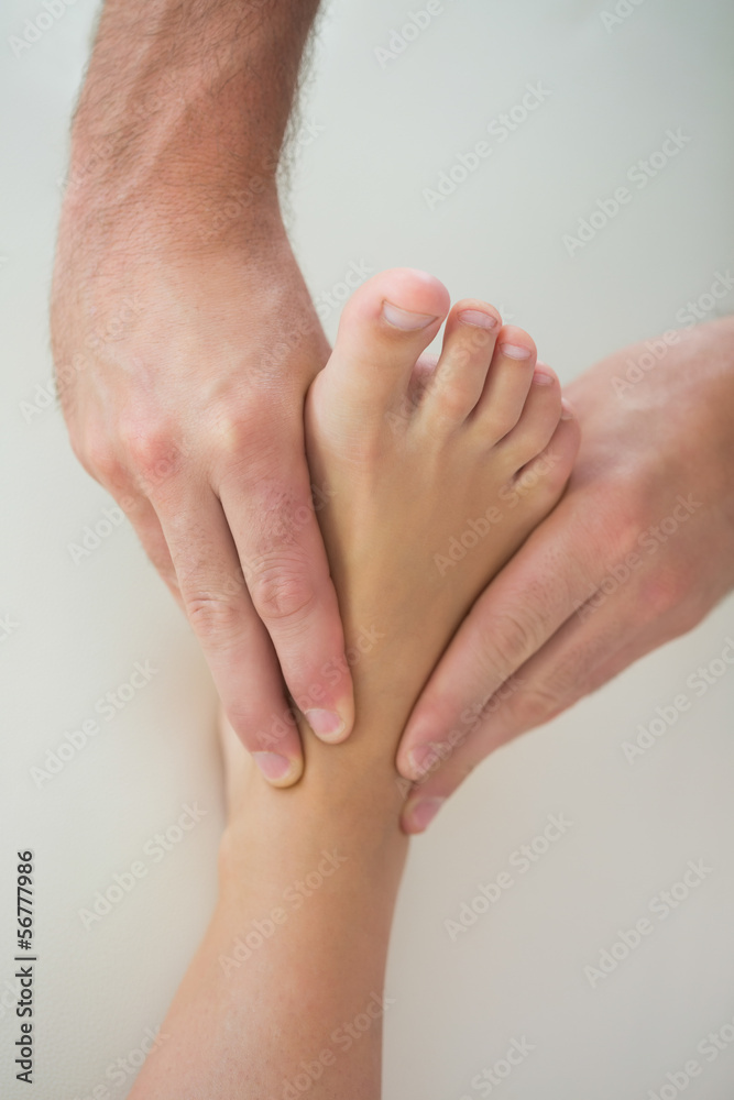Fototapeta premium Close up of physiotherapist kneading patients foot