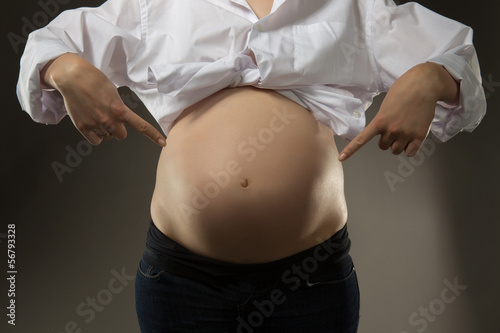 women points to the bottom of his belly photo
