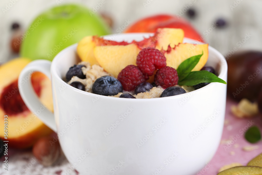 Oatmeal in cup with berries on napkins on wooden table Oatmeal in cup with berries on napkins on wooden table