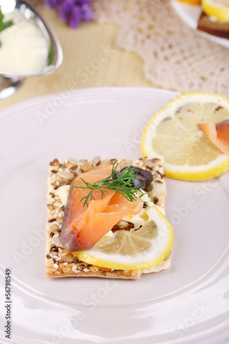 Salmon sandwiches on plate on wooden table close-up