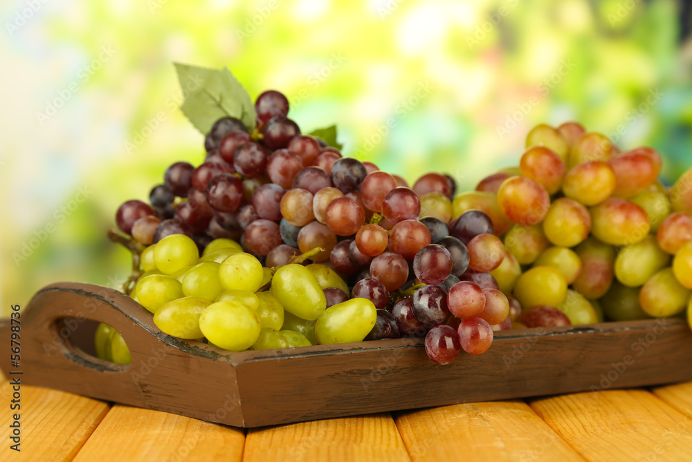 Fresh grape on wooden tray on bright background Fresh grape on wooden tray on bright background