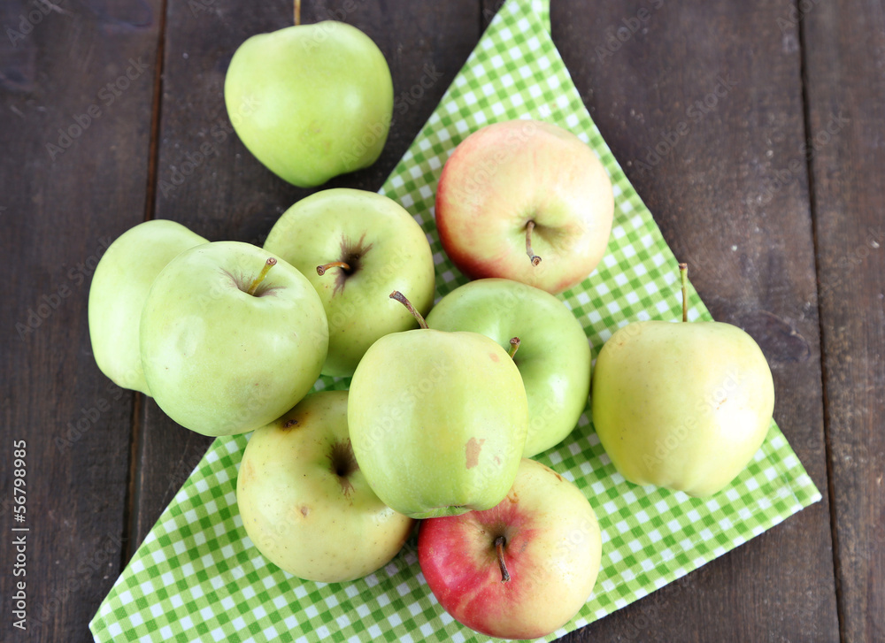 Juicy apples on napkin on wooden table Juicy apples on napkin on wooden table