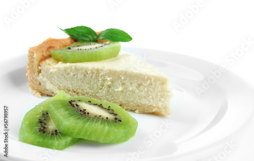 Slice of cheesecake with kiwi fruit on plate, isolated on white