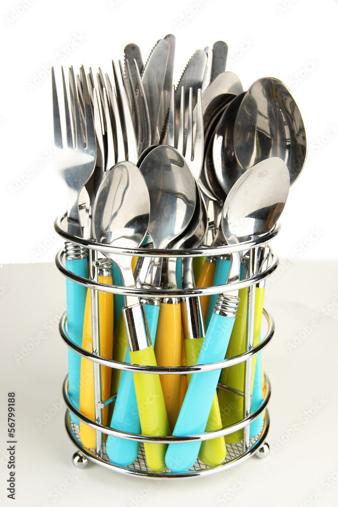 Knives, forks and spoons in metal stand isolated on white Knives, forks and spoons in metal stand isolated on white